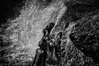 Una imagen en blanco y negro de niños disfrutando en una cascada gana el concurso "Objetivo África"